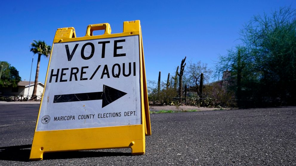 FILE - A sign marks the entrance to a voting precinct on the first day of early voting in the general election in Phoenix, Oct. 12, 2022. Arizona Latinos responded to a tough crackdown on immigrants by building a turnout machine that helped propel De