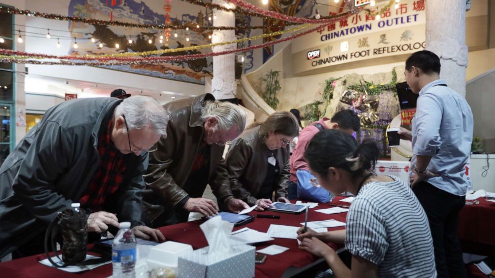 PHOTO: Poll workers check voters in during early voting in the Nevada Caucus at Chinatown Plaza Mall February 15, 2020 in Las Vegas, Nevada.