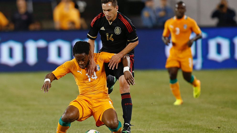 Christian Gimenez #14 of Mexico defends Jean-Jaques Gasso #14 of Ivory Coast during their match at MetLife Stadium on August 14, 2013 in East Rutherford, New Jersey. 