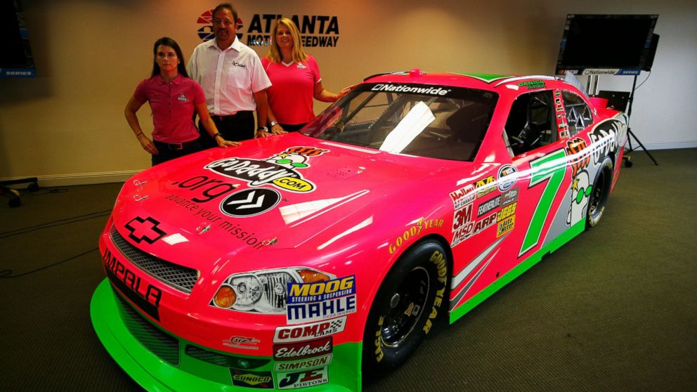PHOTO: (L-R) Danica Patrick, driver of the #7 GoDaddy.com Chevrolet, Chris Williams from Chase Authentics and Teri D'Hooge from godaddy.com pose next to the #7 car which has a special paint scheme to raise money for Breast Cancer awareness. 