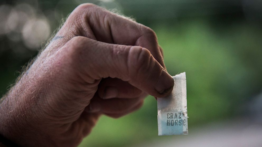 Reggy Colby, age 30 and a recovering heroin addict,  displays a bag heroin is sold in, on August 21, 2013 in Camden, New Jersey.