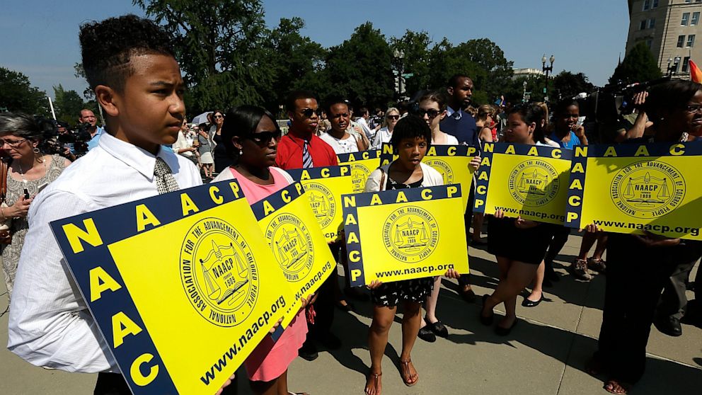 PHOTO: Supporters of the National Association for the Advancement of Colored People (NAACP) hold signs outside the U.S. Supreme Court building on June 25, 2013 in Washington, D.C. 