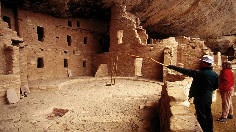 Tourists look at Spruce Tree House in Mesa Verde National Park in Colorado. 