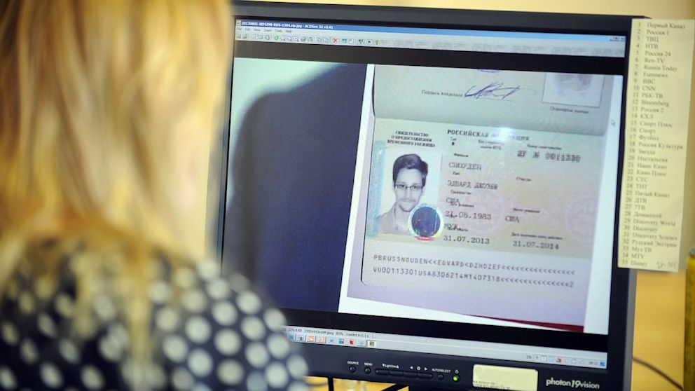 A woman watches a footage on her computer, showing  the lawyer of fugitive US intelligence leaker Edward Snowden showing his client's one year's asylum permit at Sheremetyevo airport in Moscow.