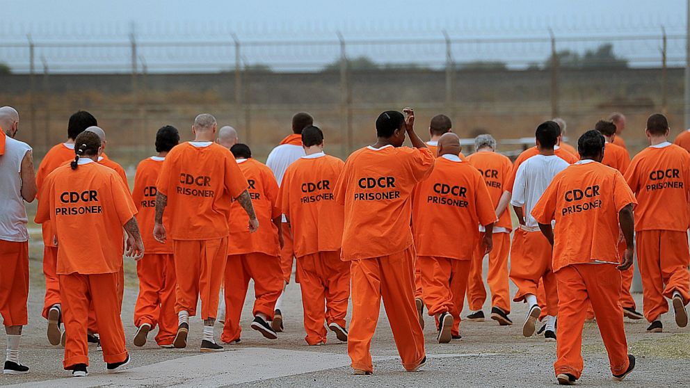 Prisoners walk a lap in a recreation yard at Deuel Vocational Institution in Tracy, California.