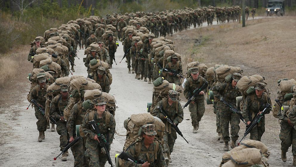 A company of Marines, both male and female, participate in a 10 kilometer training march carrying 55 pound packs during Marine Combat Training (MCT) on February 22, 2013 at Camp Lejeune, North Carolina.