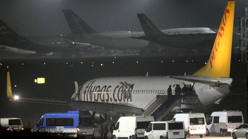 Turkish security officials enter the private Turkish company Pegasus plane before they evacuate passengers at the Sabiha Gokcen Airport in Istanbul, Turkey, Feb. 7, 2014. An official says authorities have subdued a man who attempted to hijack a Turkish plane to Sochi, Russia, and that the other passengers have been evacuated.