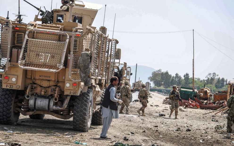 PHOTO: Members of the Afghan security forces inspect the site of a suicide bomb attack targeting a convoy of U.S. forces near Nangarhar airport, Afghanistan, April 10, 2015. 