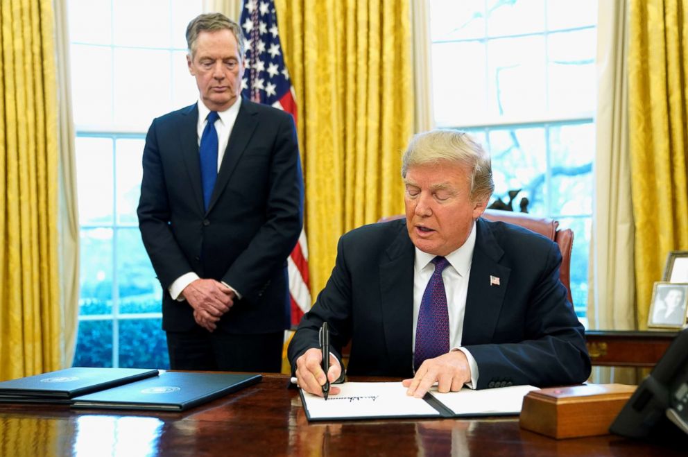 PHOTO: President Donald Trump, flanked by U.S. Trade Representative Robert Lighthizer, signs a directive to impose tariffs on imported washing machines in the Oval Office at the White House in Washington, D.C. Jan. 23, 2018.