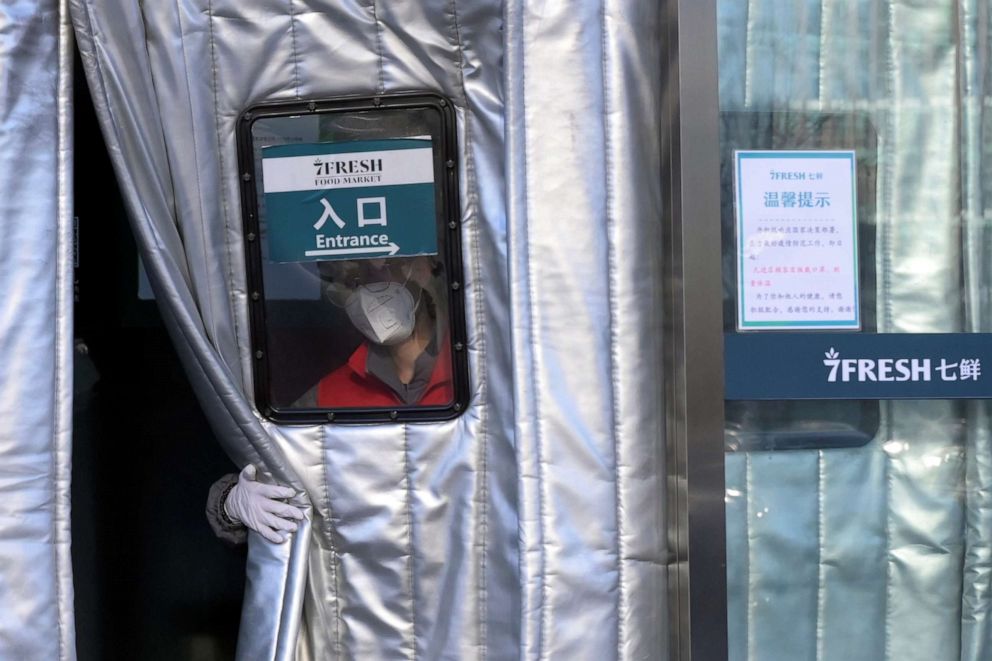 PHOTO: A staff member wearing a face mask opens the door curtain for customers at a JD.com's 7Fresh chain, as the country fights the novel coronavirus, in Yizhuang town, Beijing, Feb. 8, 2020.