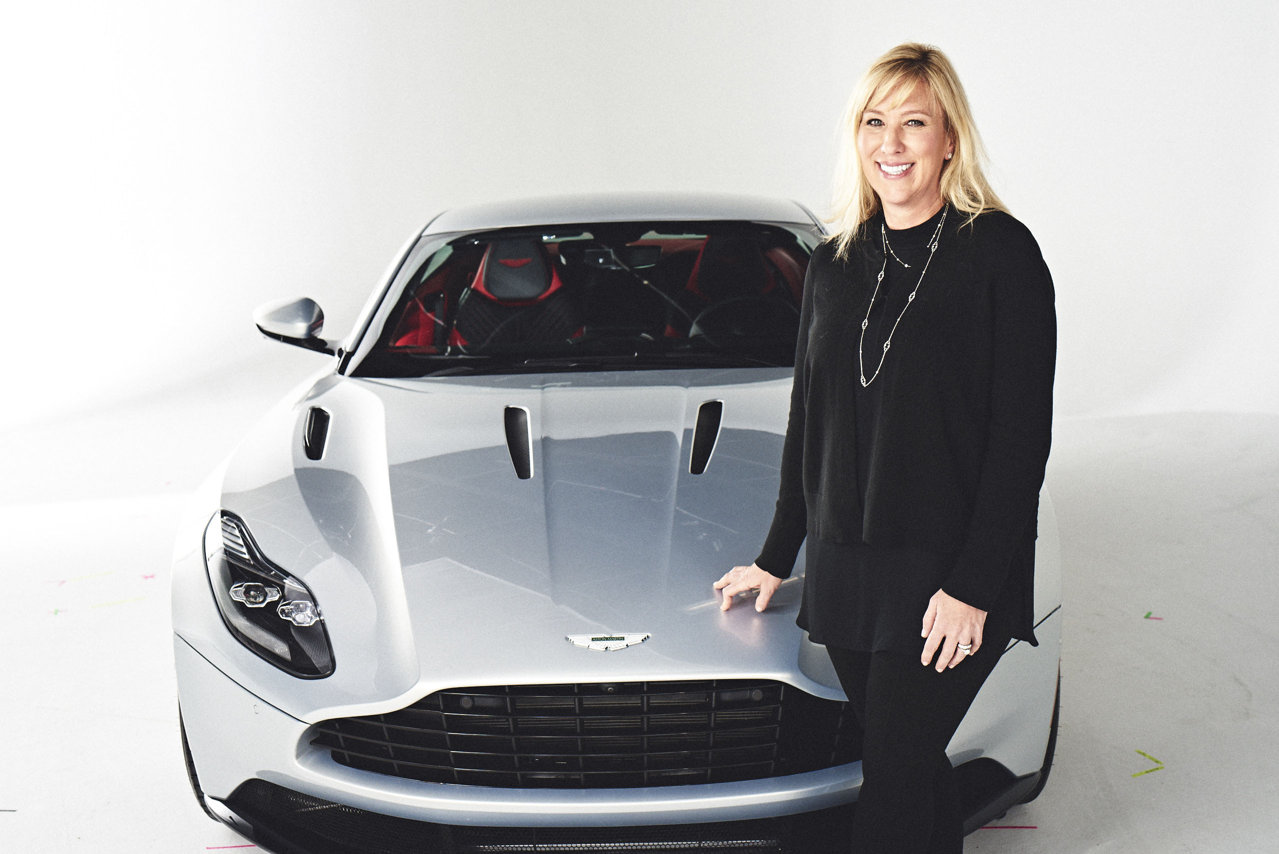 PHOTO: Laura Schwab stands next to an Aston Martin DB11.