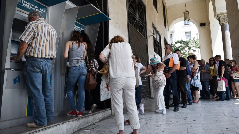 PHOTO: People line up at ATMs outside a National bank branch, June 29, 2015, in the northern Greek port city of Thessaloniki.