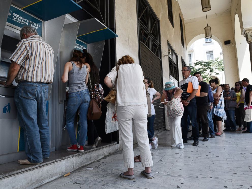 PHOTO: People line up at ATMs outside a National bank branch, June 29, 2015, in the northern Greek port city of Thessaloniki.