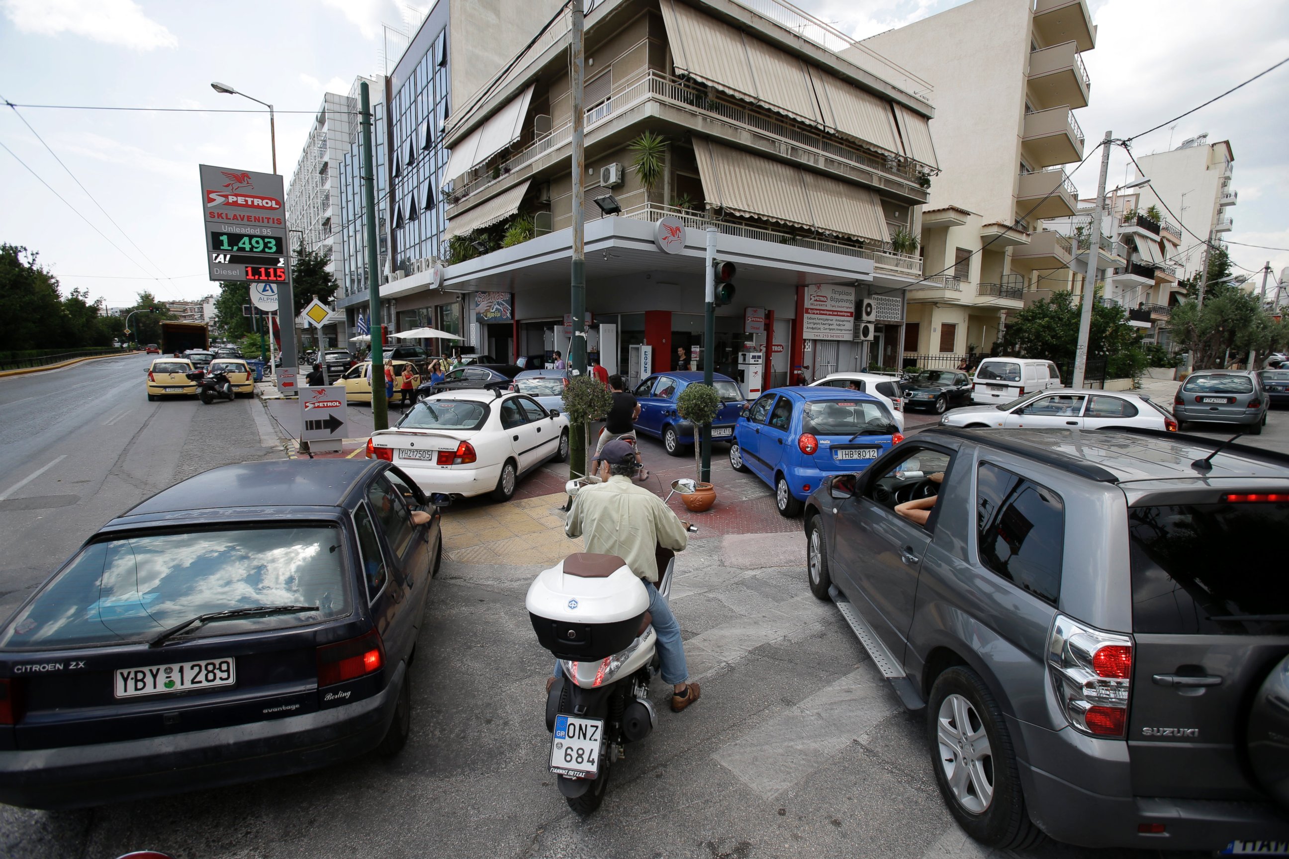 PHOTO: Drivers wait to fill their cars and scooters at a filling station, June 29, 2015, in Athens.