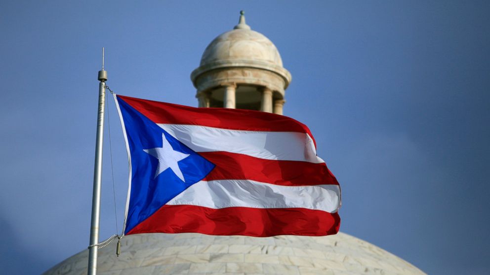 In this July 29, 2015 file photo, the Puerto Rican flag flies in front of Puerto Rico's Capitol in San Juan, Puerto Rico. The White House plans to announce the members of a new oversight board to help manage Puerto Rico's debt-stricken economy. 