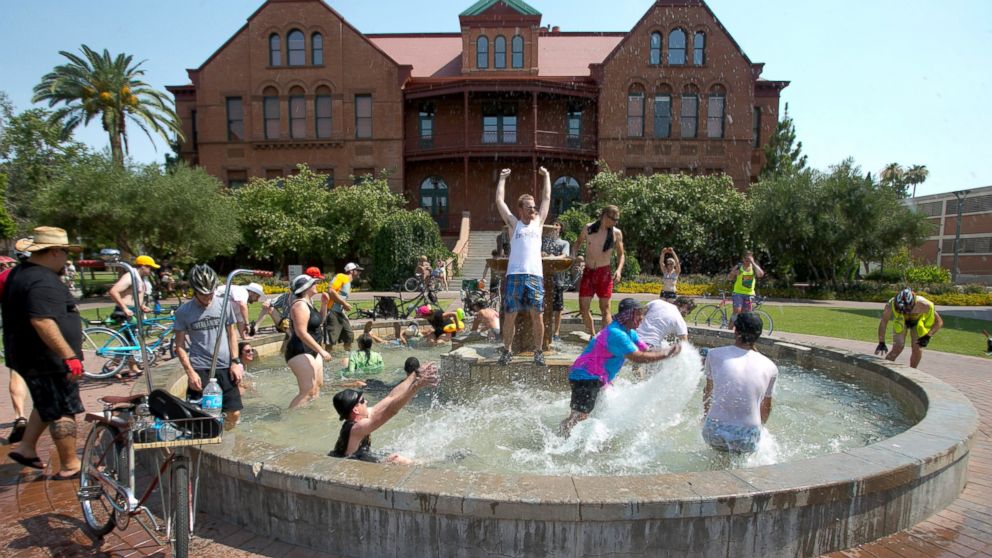 PHOTO: People cool off in the fountain in front of Old Main on Arizona State University campus in Tempe, Ariz. during the Tempe Bicycle Action Group swimsuit ride, June 29, 2013. 