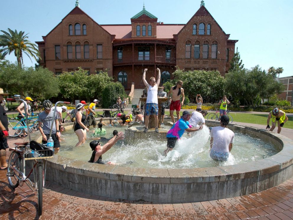 PHOTO: People cool off in the fountain in front of Old Main on Arizona State University campus in Tempe, Ariz. during the Tempe Bicycle Action Group swimsuit ride, June 29, 2013.