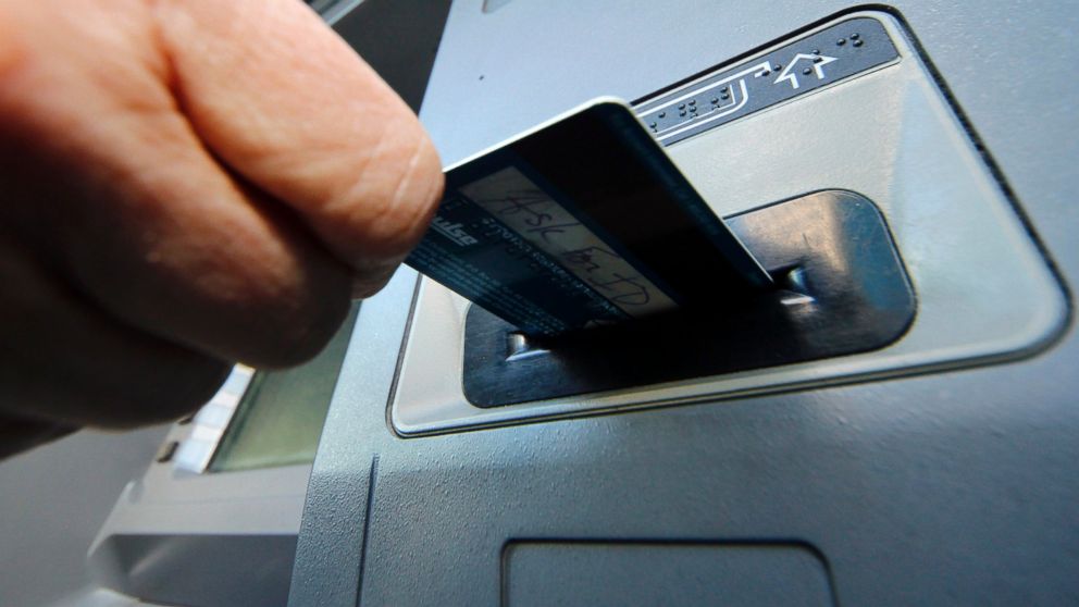 A person inserts a debit card into an ATM in Pittsburgh, Jan. 5, 2013.