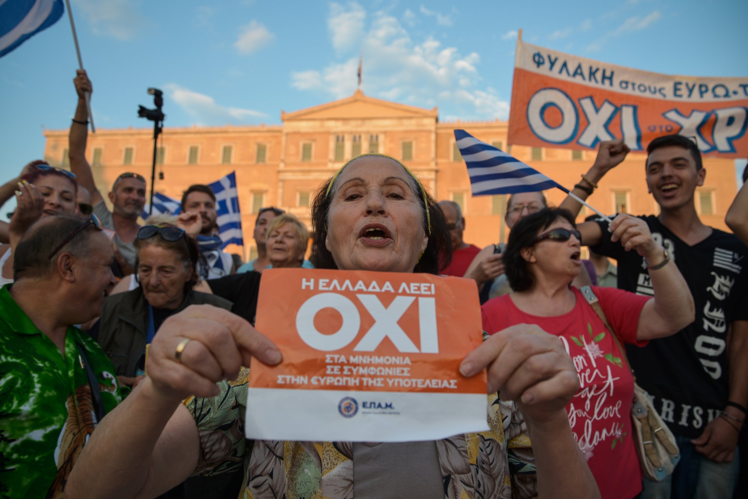 PHOTO: A woman holds a flyer which reads "Greece says NO" during a mass anti-EU rally in Athens on June 29,2015. 