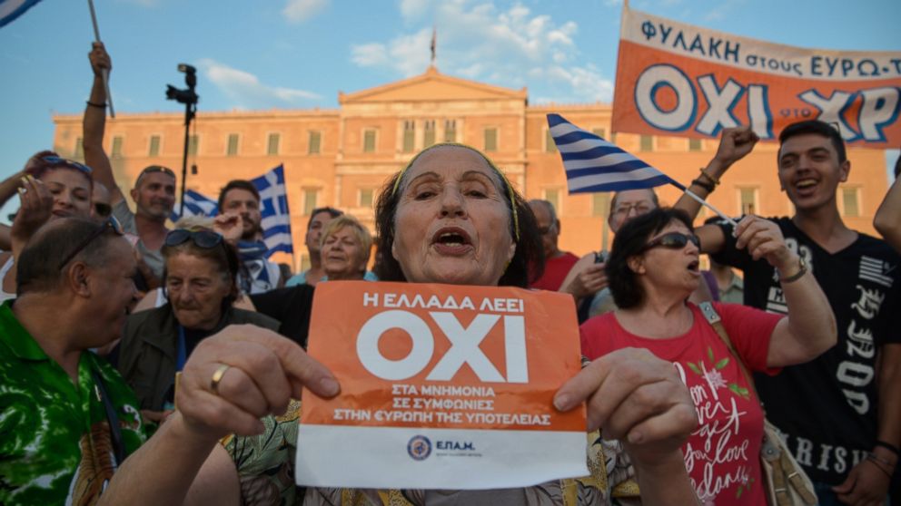 PHOTO: A woman holds a flyer which reads "Greece says NO" during a mass anti-EU rally in Athens on June 29,2015. 