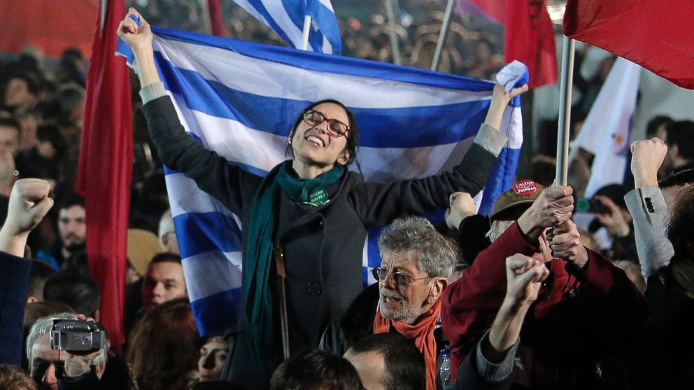 A supporter of Alexis Tsipras, leader of the left-wing Syriza party holds a Greek flag during a rally outside Athens University Headquarters, Jan. 25, 2015. 