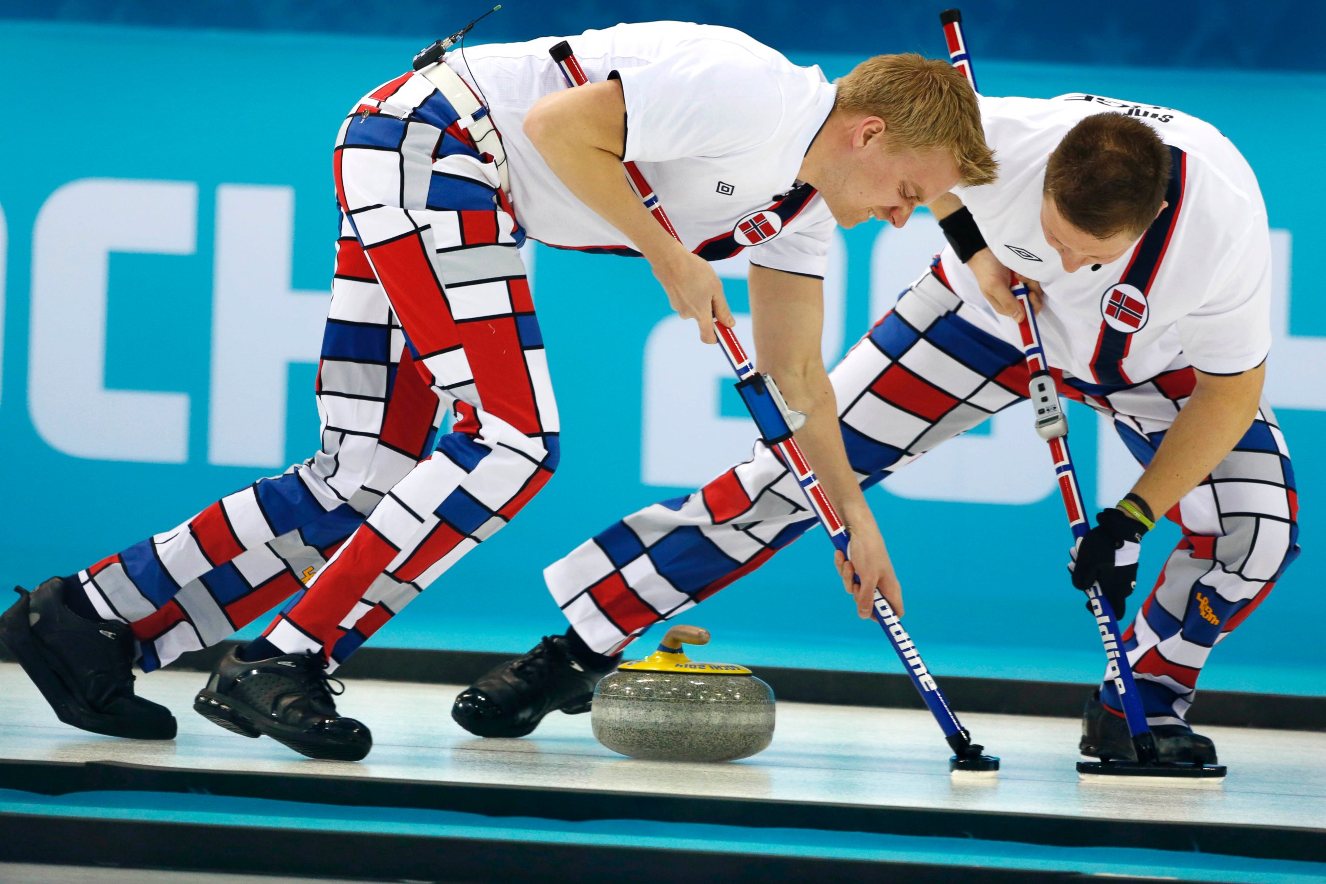 PHOTO: Norway's Haavard Vad Petersson, left, and Christoffer Svae sweep during men's curling competition against Team USA at the 2014 Winter Olympics, Feb. 10, 2014, in Sochi, Russia.