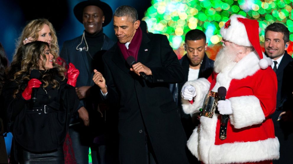 President Barack Obama dances on stage with Santa, members of Fifth Harmony, left, Chely Wright, Nico & Vinz and a member of The Tenors, behind, during the National Christmas Tree lighting ceremony at the Ellipse near the White House in Washington, Dec. 4, 2014.