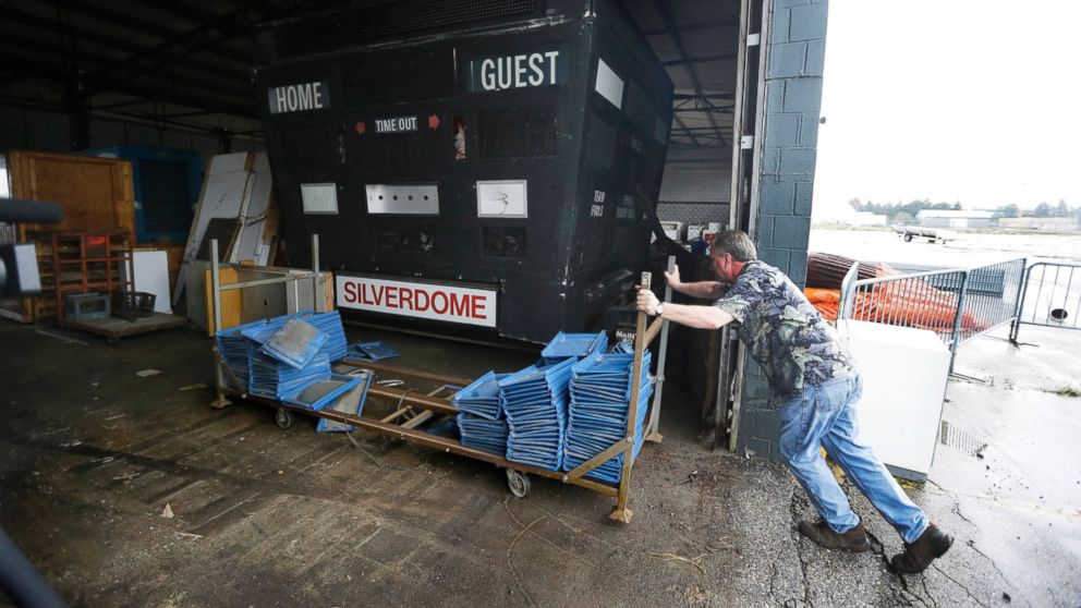 Jim Passeno of RJM Auctions moves a trailer next to the Detroit Pistons scoreboard on the Pontiac Silverdome's property in Pontiac, Mich. in this May 12, 2014 photo.