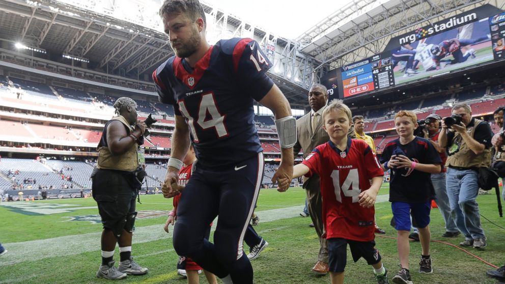 Houston Texans' Ryan Fitzpatrick walks with his children following an NFL football game against the Tennessee Titans, Nov. 30, 2014, in Houston. 