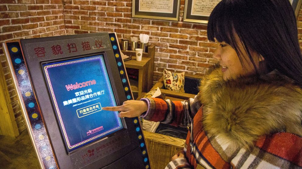 A customer uses a face-scanning machine at a restaurant offering free meals to customers who earn high marks for their looks in Zhengzhou city, China, Jan. 11, 2015.