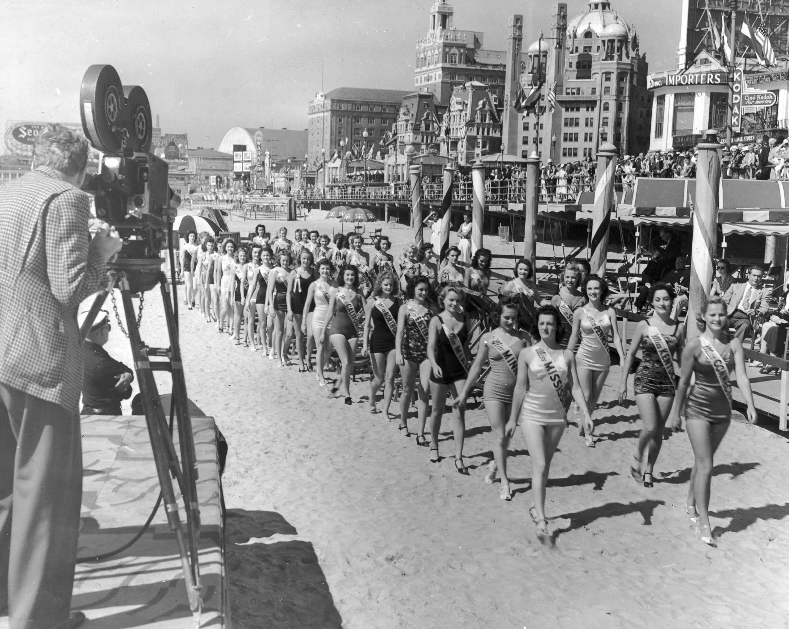 PHOTO: A cameraman films contestants in the Miss America Pageant as they walk on the beach next to the boardwalk at Atlantic City, N.J., Jan. 9, 1939.