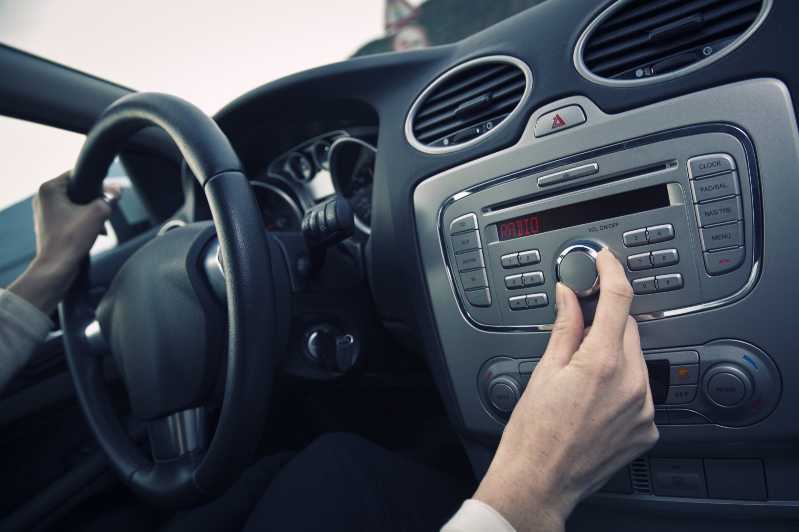 PHOTO: A man adjust the volume of a car stereo in this stock image.