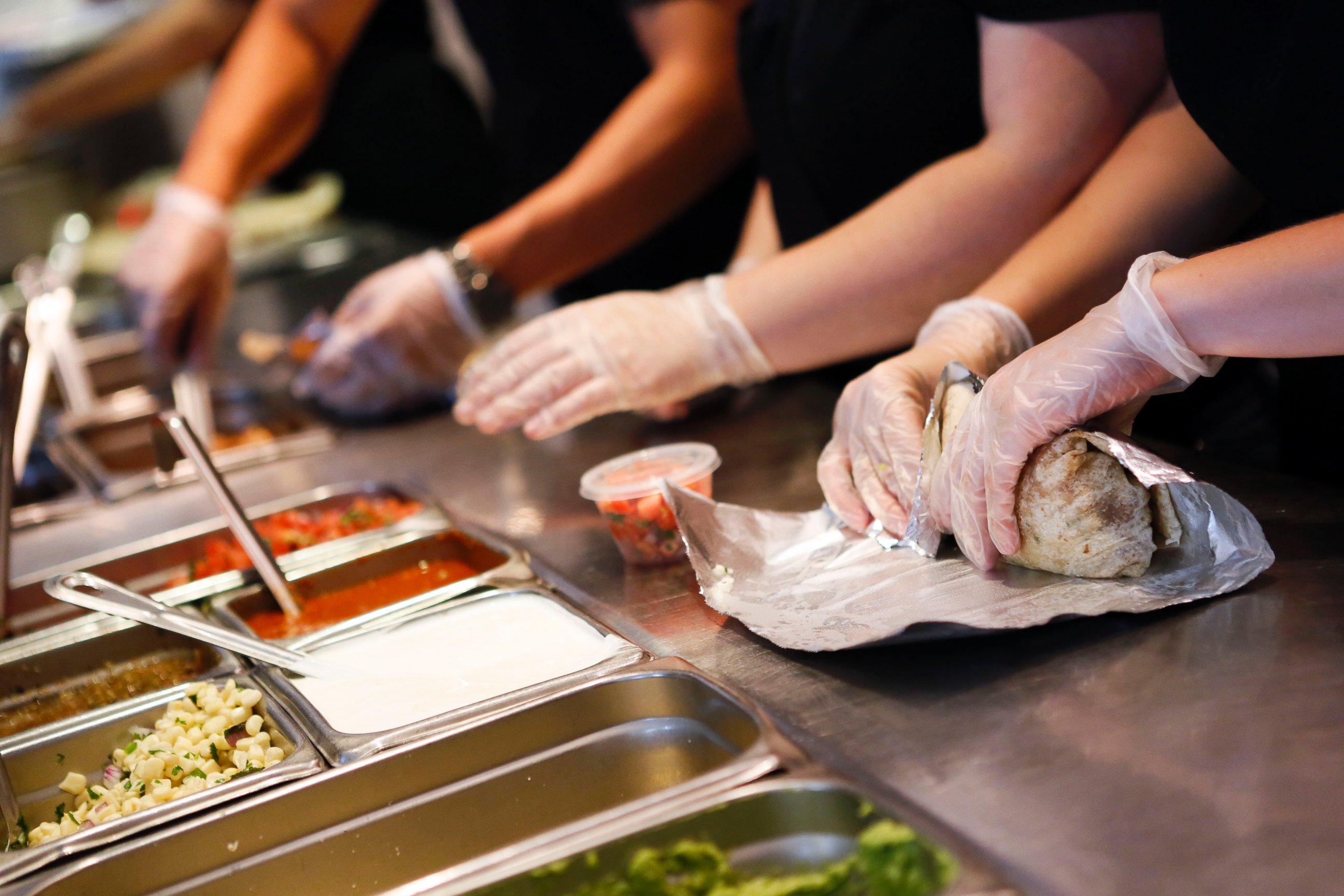 PHOTO: Employees prepare orders for customers at a Chipotle in Hollywood, Calif. on July 16, 2013. 
