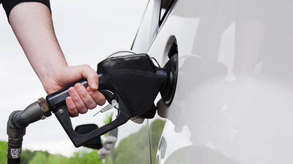 A man holding a gas pump refuels his car in this undated stock photo.