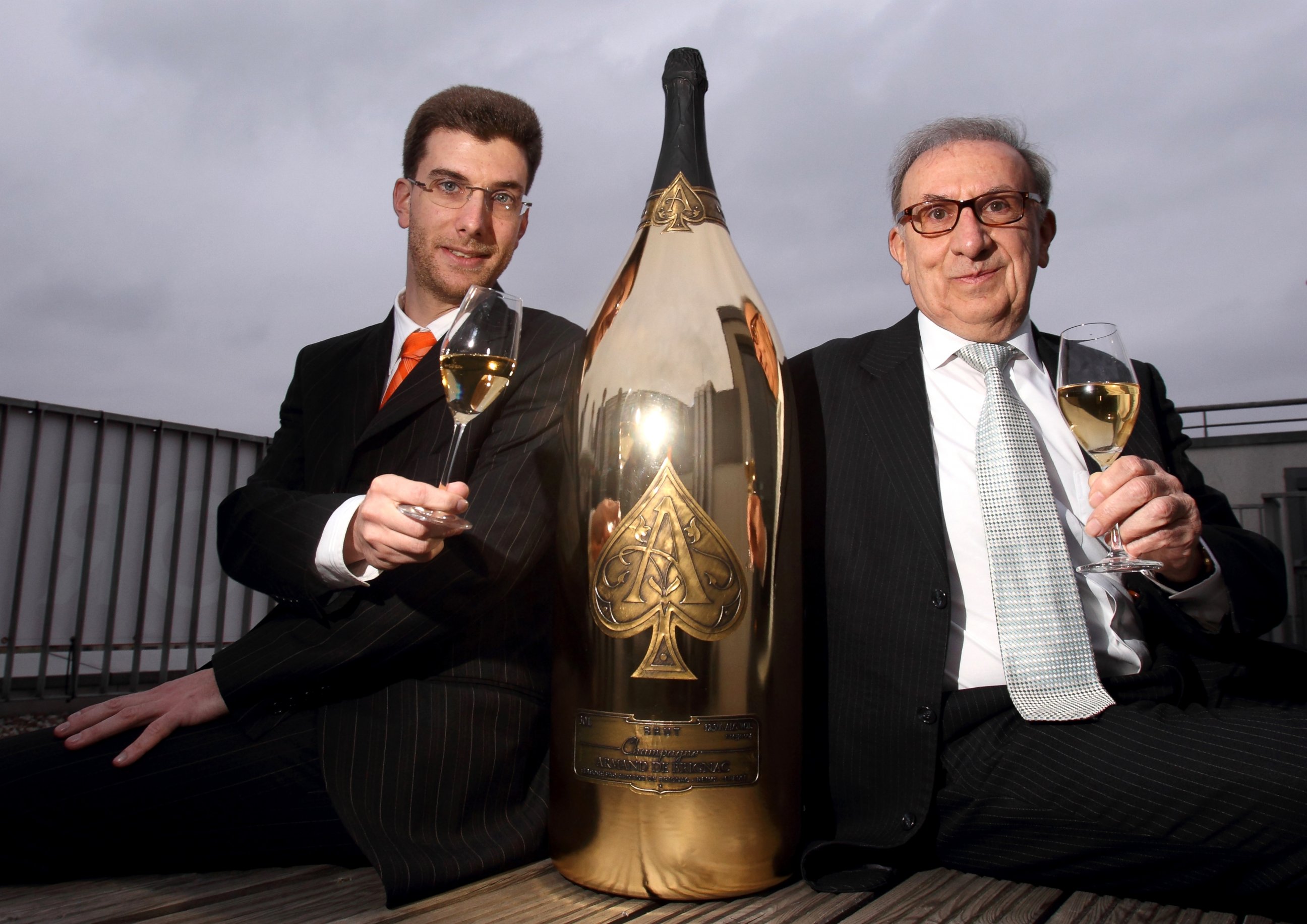 PHOTO: Jean-Jacques Cattier, right, and his son, Alexandre Cattier, pose with the world largest bottle of Champagne "The Midas" by Armand de Brignac, April 6, 2011, in Berlin.