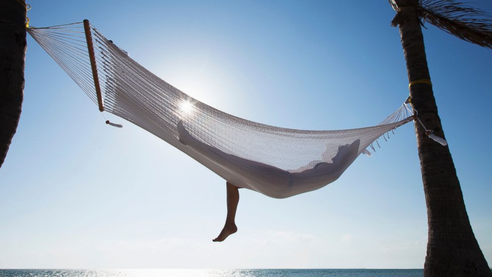 A woman is pictured relaxing on a hammock in this stock image.