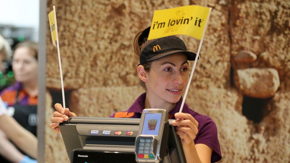 An employee waves "I'm Lovin' It" flags at a McDonald's in Moscow, Russia, on Oct. 28, 2014. 