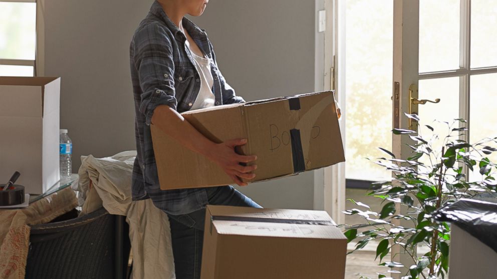 A woman is seen carrying boxes while moving from her home in this undated file photo. 