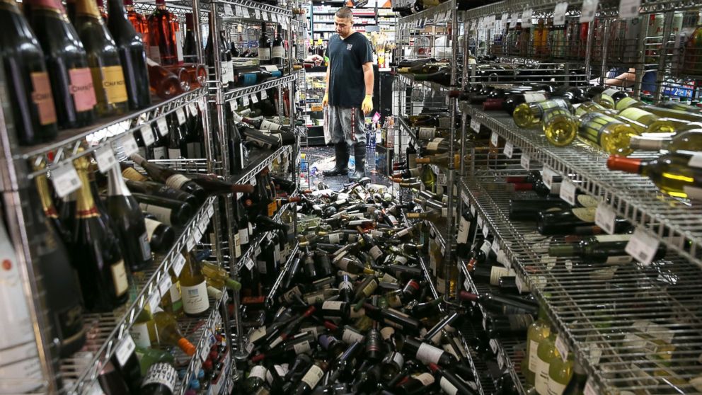 PHOTO: A worker looks at a pile of wine bottles that were thrown from the shelves at Van's Liquors following a reported 6.0 earthquake on Aug. 24, 2014 in Napa, Calif.