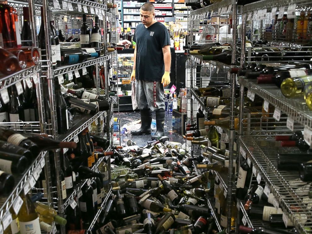 PHOTO: A worker looks at a pile of wine bottles that were thrown from the shelves at Vans Liquors following a reported 6.0 earthquake on Aug. 24, 2014 in Napa, Calif.