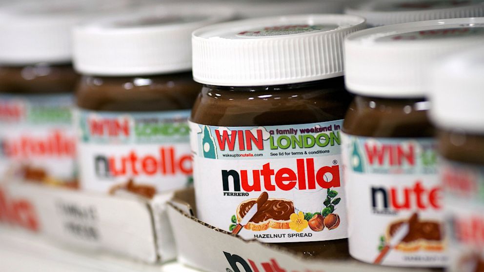 PHOTO: Jars of nutella hazelnut chocolate spread, manufactured by Ferrero S.p.A., sit in boxes on a shelf inside a supermarket.