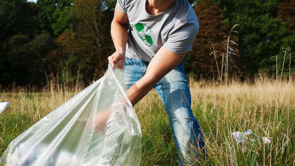 A young man collecting trash is pictured in this stock photo. 