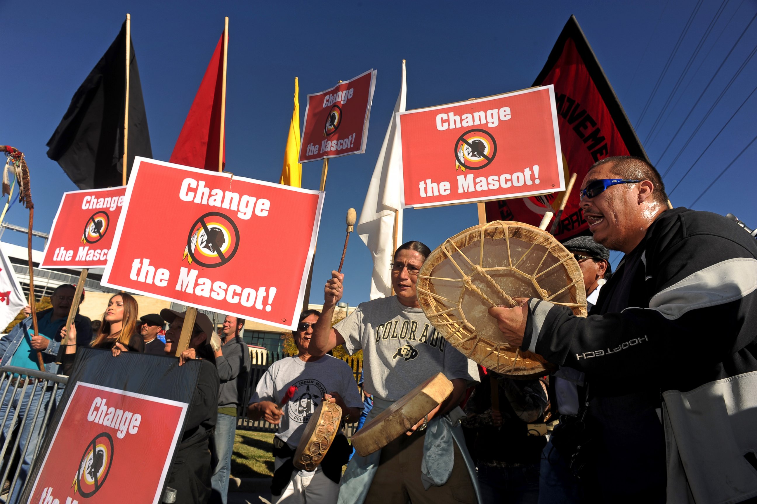 PHOTO: Protesters sing and play the drums outside of Sports Authority Field at Mile High in Denver