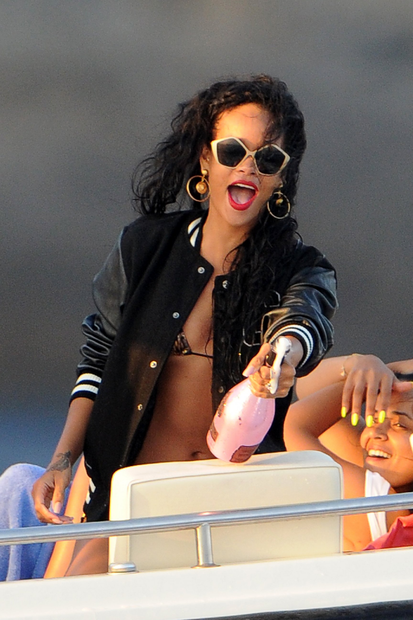 PHOTO: Rihanna is seen opening a bottle of champagne on a boat, July 28, 2012, in Portofino, Italy.