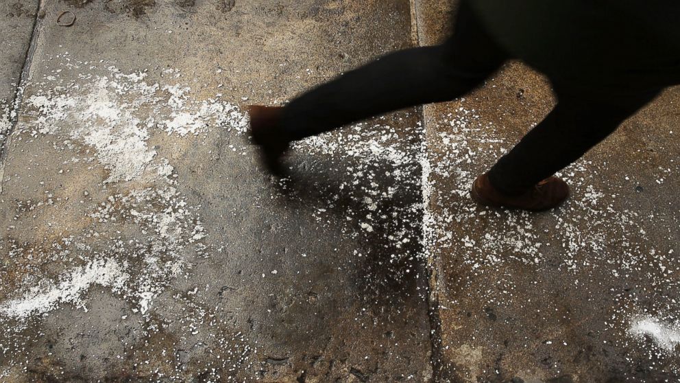 A person walks on a city sidewalk covered in salt, Feb. 12, 2014 in New York.