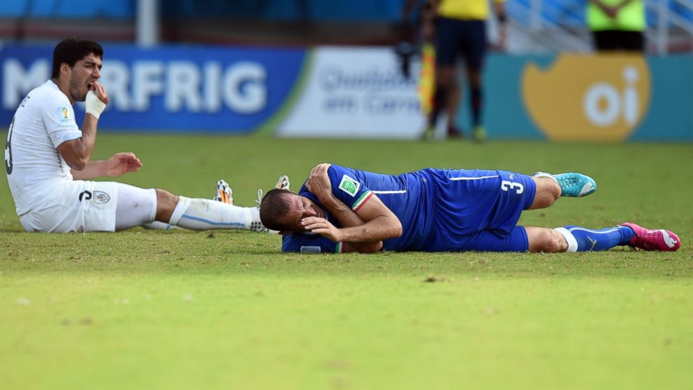Uruguay's forward Luis Suarez left, reacts past Italy's defender Giorgio Chiellini during a Group D football match between Italy and Uruguay at the Dunas Arena in Natal during the 2014 FIFA World Cup on June 24, 2014.      