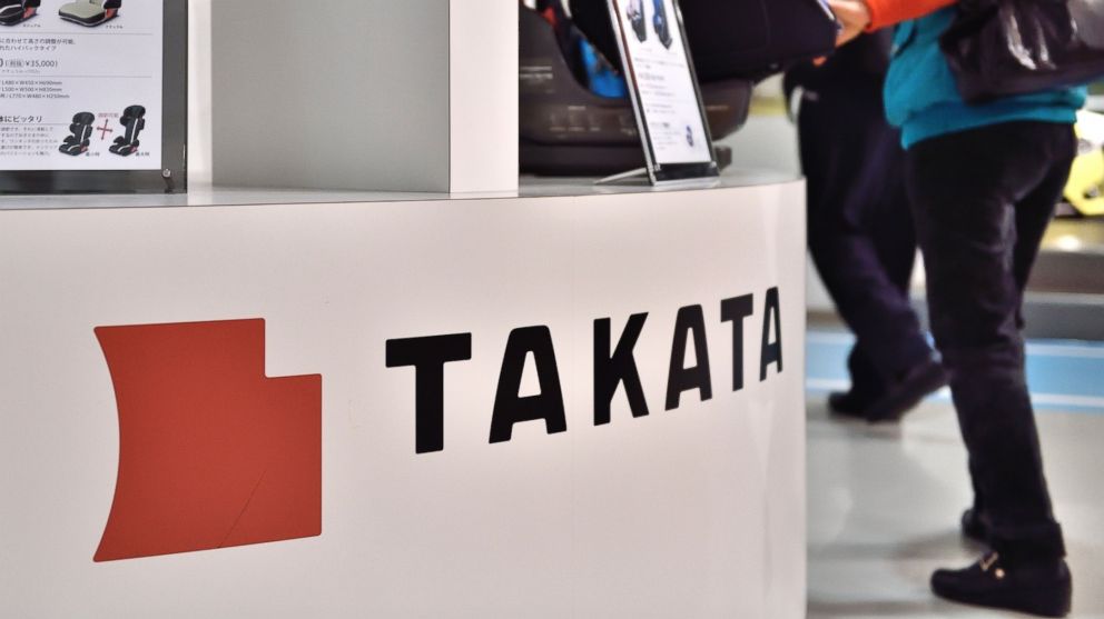 Visitors walk past displays of Japanese auto parts maker Takata Corp. at a car showroom in Tokyo on Nov. 11, 2014. 