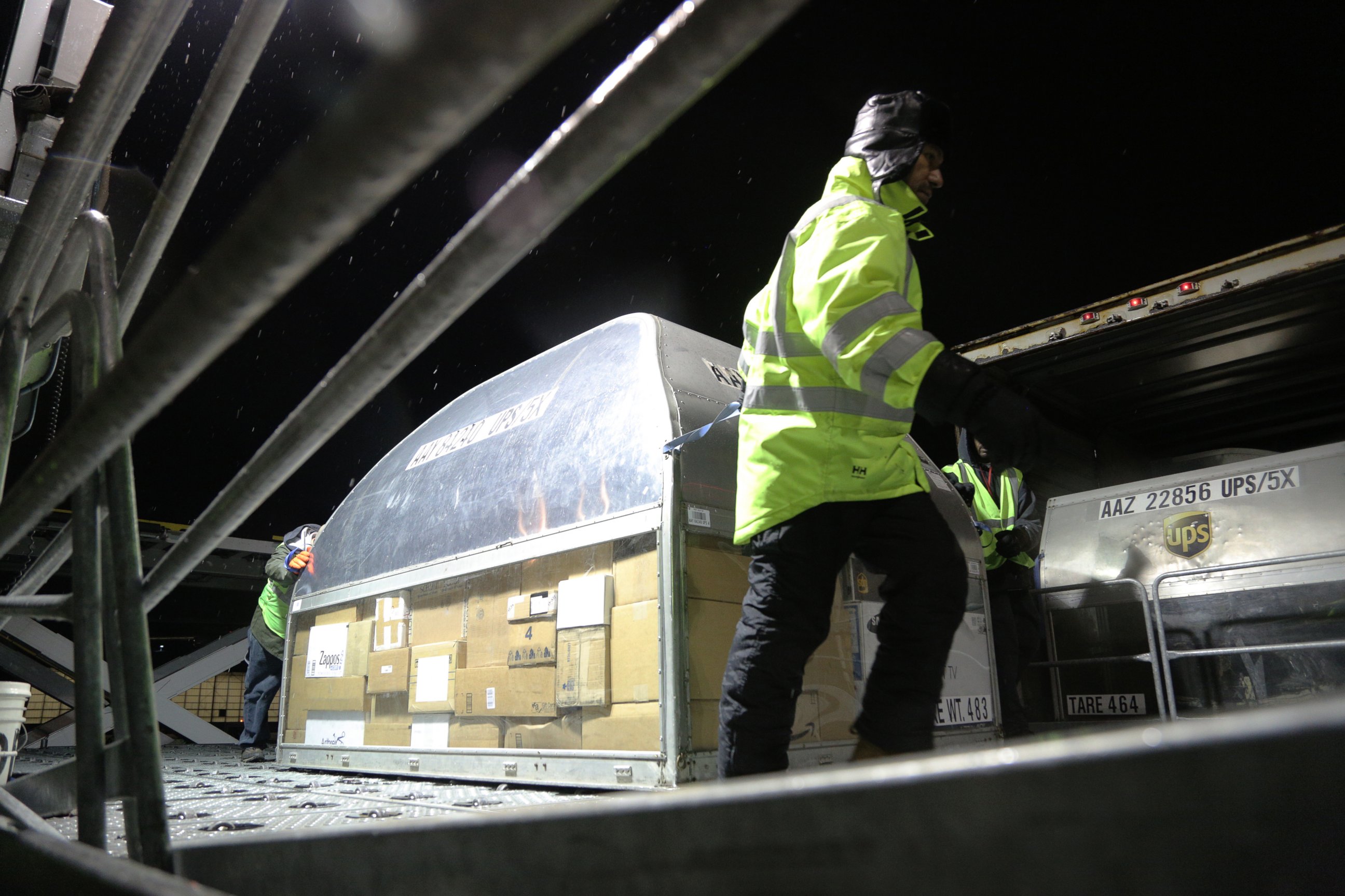 PHOTO: Employees at UPS' Logan Airport facility load packages from an early morning plane 