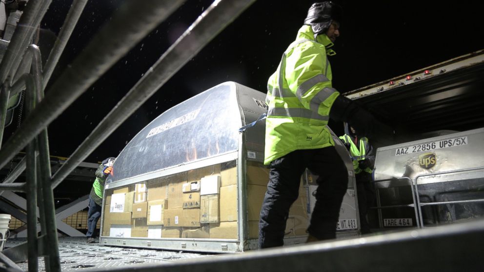 PHOTO: Employees at UPS' Logan Airport facility load packages from an early morning plane 