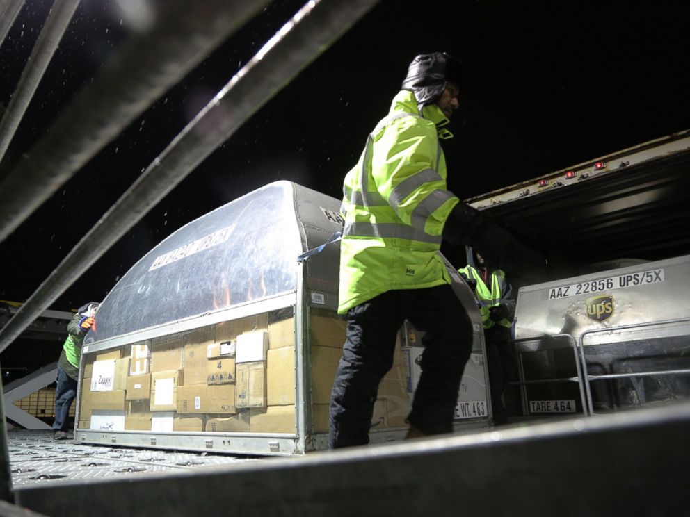 PHOTO: Employees at UPS Logan Airport facility load packages from an early morning plane